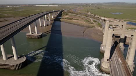 Panorama-De-La-Conducción-De-Vehículos-En-El-Cruce-De-Sheppey-Y-Una-Carrera-De-Jetski-Alrededor-Del-Puente-Kingsberry-En-Inglaterra