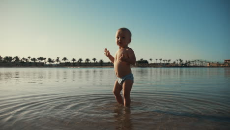 Sweet-child-staying-at-sea-bay.-Adorable-baby-boy-looking-to-resort-beach.