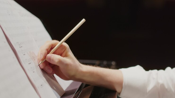Komponist erstellt Noten am Klavier.