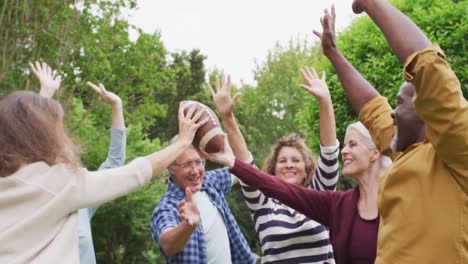 animation of happy diverse female and male senior friends playing american football in garden