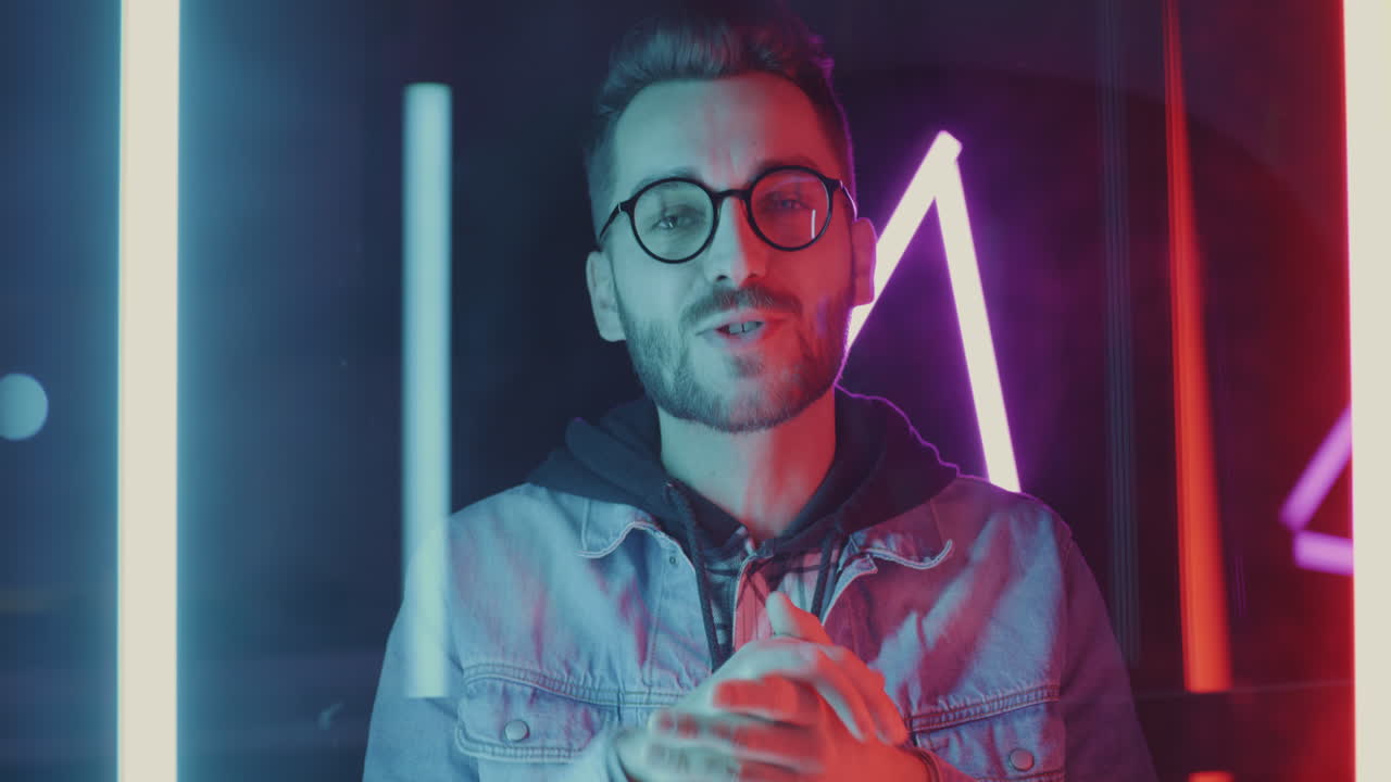 Man Smiling and Gesturing in Neon Light