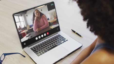 Mujer-Afroamericana-Usando-Una-Computadora-Portátil-Para-Videollamadas,-Con-Un-Colega-De-Negocios-En-La-Pantalla