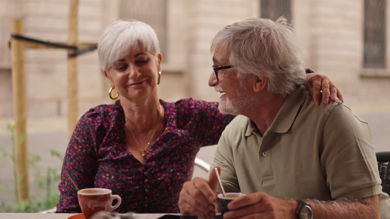 Affectionate Elderly Couple Enjoying Coffee at an Outdoor Cafe