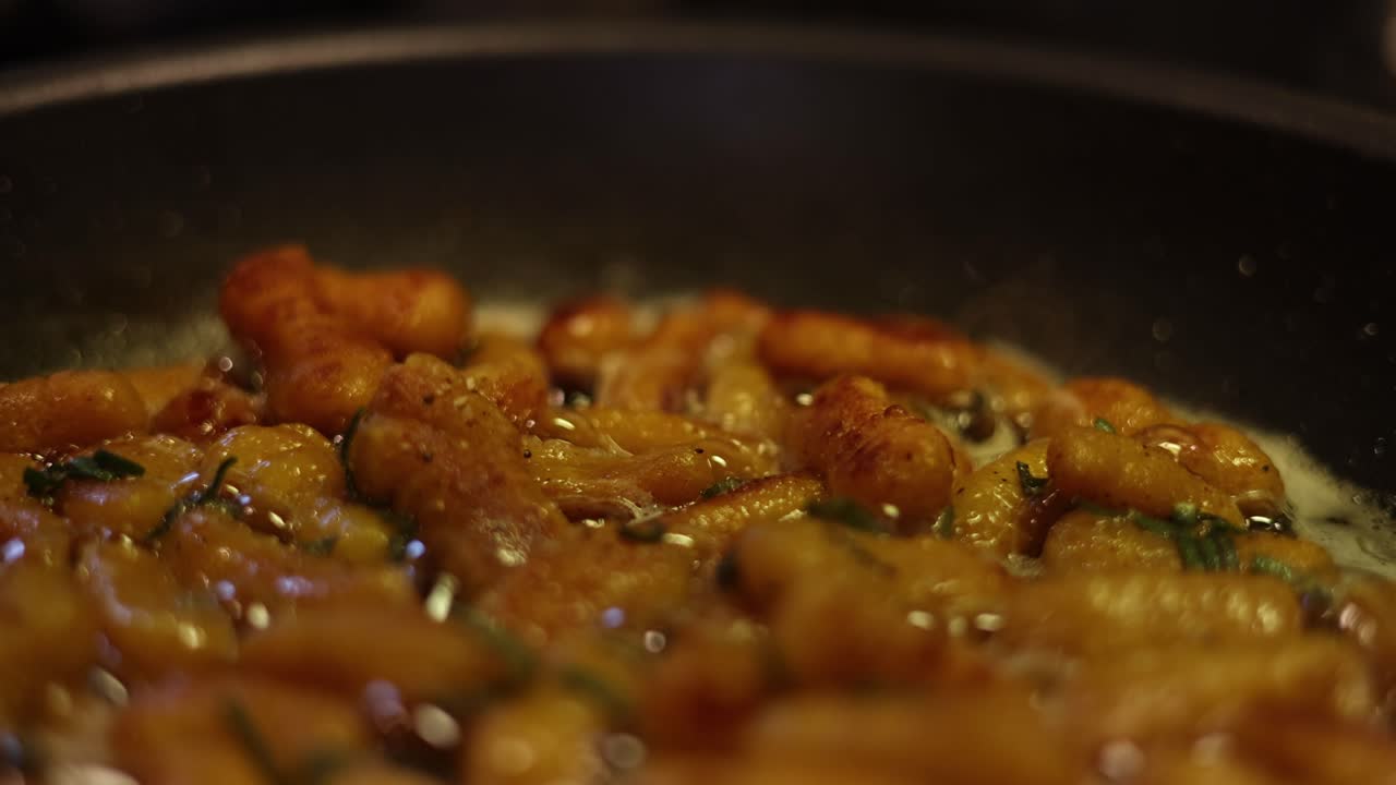 gnocchi cocinado, hirviendo y burbujeando, en una sartén caliente