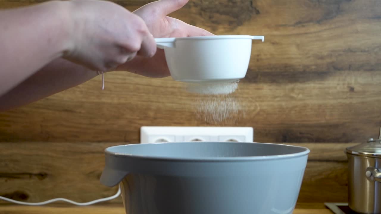 mujer tamiza la flor en un cuenco