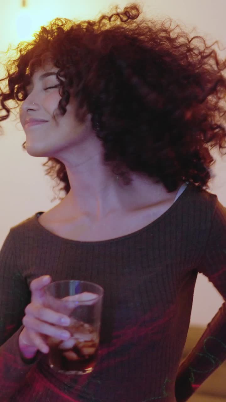 Multiethnic friends dancing and drinking in a home party night