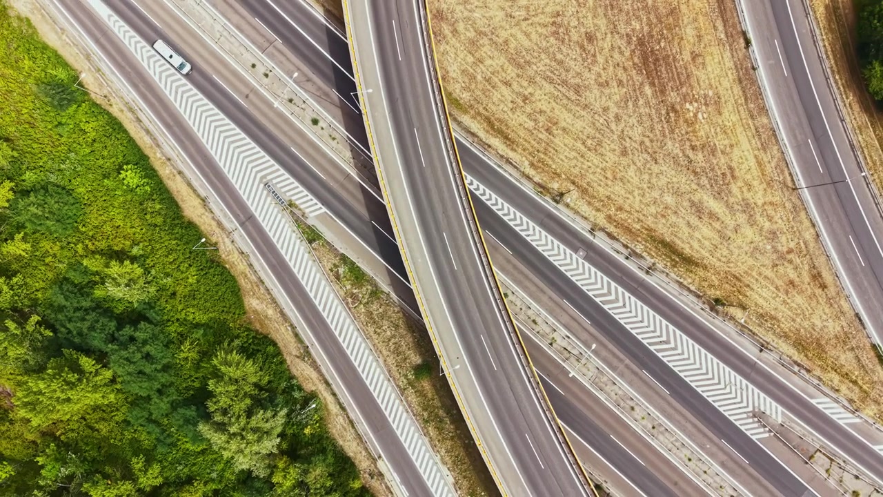 Intersezione autostradale vicino a bosco e campo di giorno.