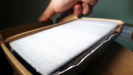 hombre abriendo un paquete y encontrando un estuche protector de teléfono