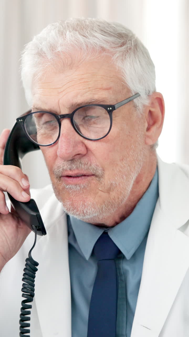 Close-up of Senior Doctor Talking on a Landline Phone
