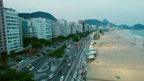 Coastline-of-Copacabana-Beach-Rio-de-Janeiro-Brazil,-Aerial-Drone-View-in-Summer-Cars-Driving-at-Main-Avenue