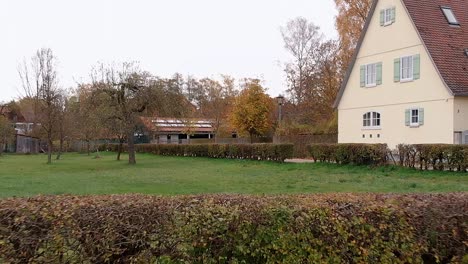 a drone flies low over the meadow passes through hedges continues to fly through the playground and lawn