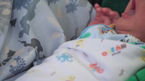 newborn baby with moving fingers touching the head