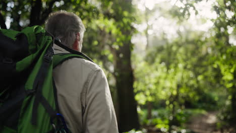 man hiking in a forest with a backpack