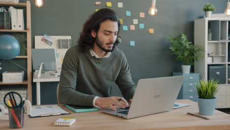 hombre trabajando en una computadora portátil en una oficina moderna