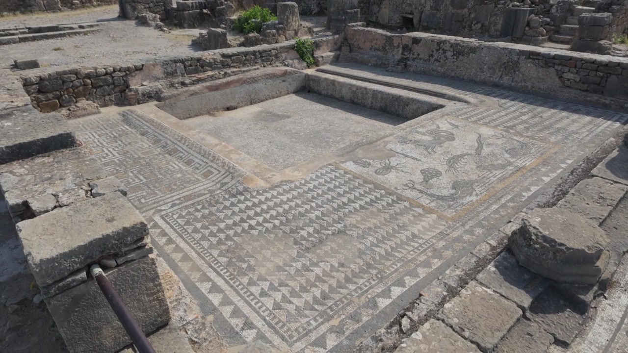 Vista ravvicinata di pavimenti a mosaico romano straordinariamente conservati nel sito archeologico di Volubilis, patrimonio UNESCO, in Marocco, che evidenziano intricati motivi geometrici e l'antica maestria artigianale.