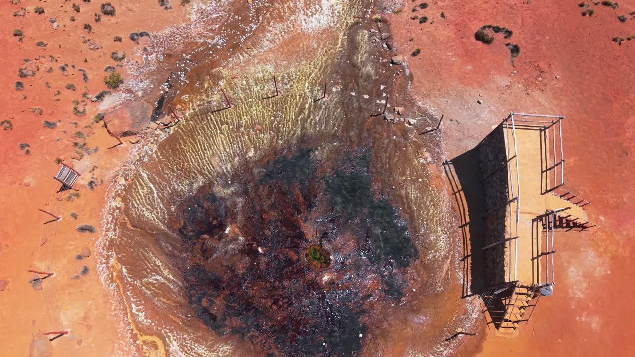 Scatto dall'alto del mini vulcano nel Parco Nazionale Salinas Laguna del Perù. La piattaforma di osservazione è visibile, mentre l'acqua ricca di minerali del cratere crea una scena vibrante e ultraterrena.