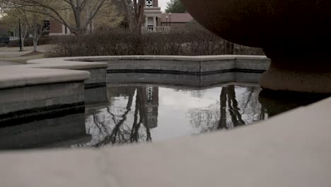 fountain with still water on the campus of ole miss in oxford, mississippi with stable establishing shot