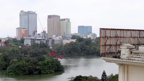 Scenic view of a city skyline with a lush island in the foreground, featuring tall buildings and greenery.