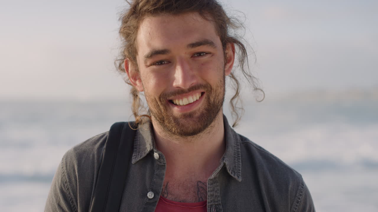 portrait of happy young man smiling enjoying successful vacation lifestyle looking cheerful independent male on warm sunny beach