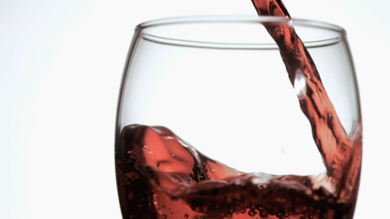 Vino rosso che cade in un bicchiere al rallentatore