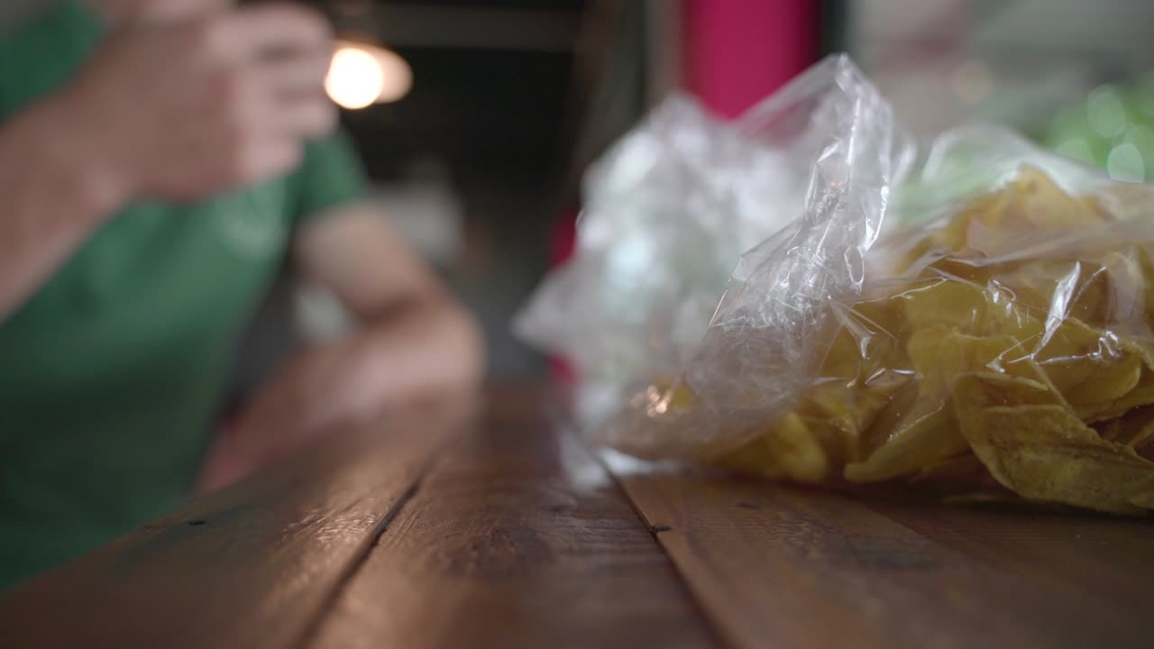 recogiendo a mano un bocadillo frito y crujiente de papas fritas de plátano