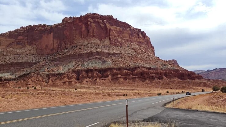 Un'auto sfreccia tra le rocce rosse dello Utah