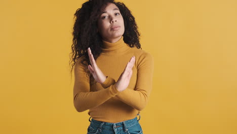 una mujer afroamericana segura de sí misma sobre un fondo naranja.