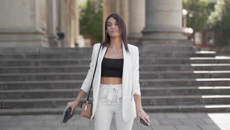 Attractive-young-woman-dancing-in-the-Street-pleased-with-herself-wearing-a-business-suit-1