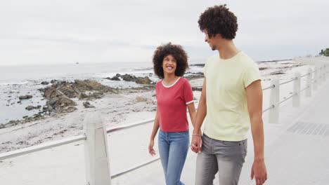 Afroamerikanisches-Junges-Paar,-Das-Händchen-Hält-Und-Gemeinsam-Auf-Der-Promenade-Spaziert