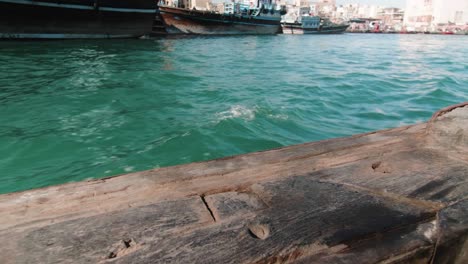 traditional wooden boat sailing the water with waves