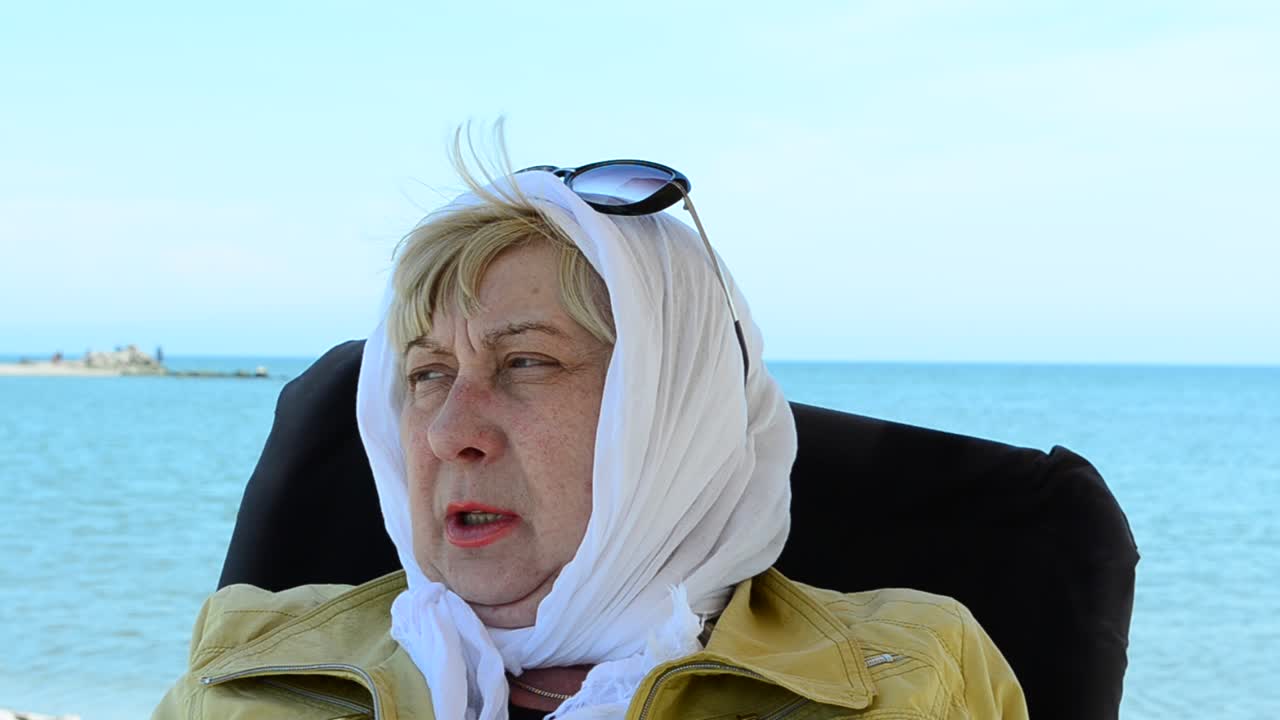 La signora su una sedia al mare. Giro in mare