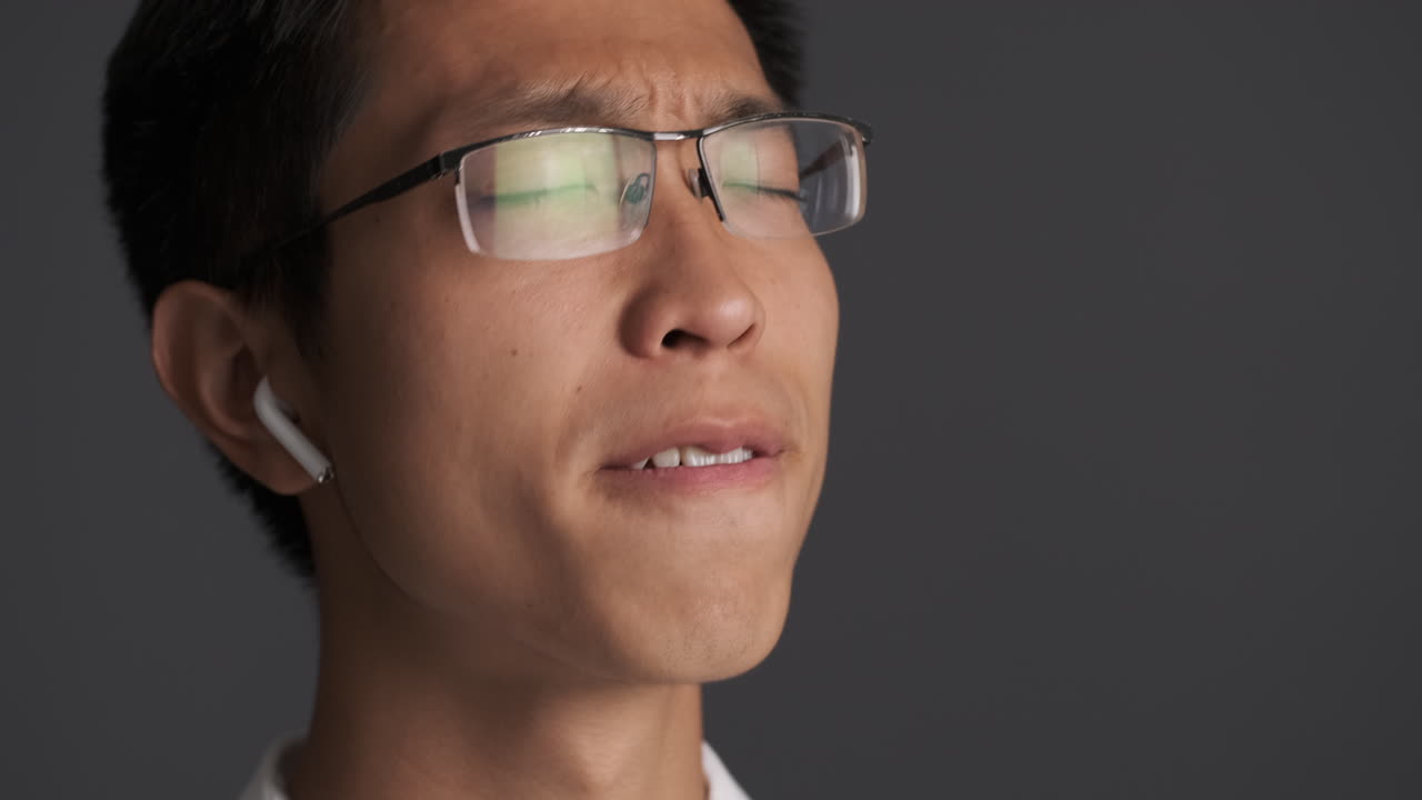 음악을 듣는 이어폰을 입은 아시아인 남자.