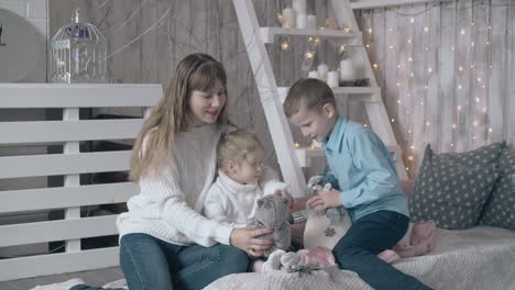 blond mother son and daughter play with stuffed soft toys