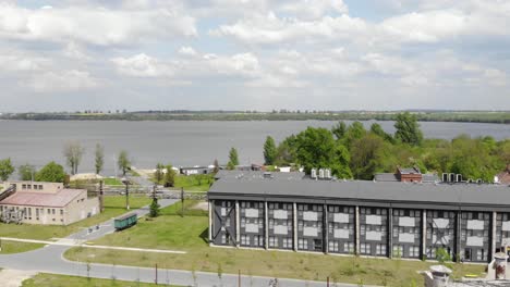 A-drone-shot-of-the-Żnin-sugar-factory-in-Poland,-with-Jezioro-Duże-Żnińskie-in-the-background