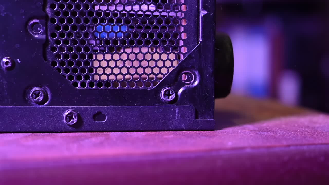 Close up of a man cleaning the dust from a computer using an air blower