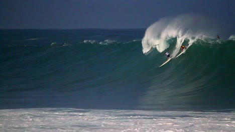 varios surfistas montan olas muy grandes en hawaii