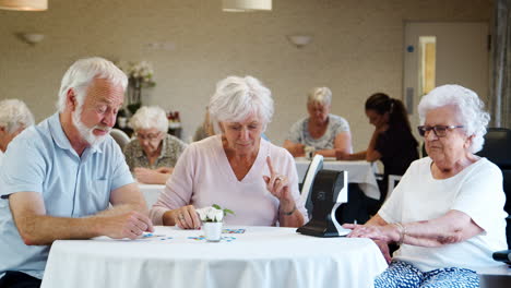 group of seniors playing game of bingo in retirement home