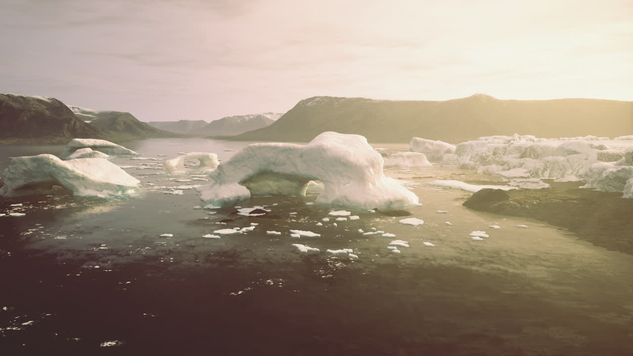 Large icebergs float on still waters under the warm glow of sunset
