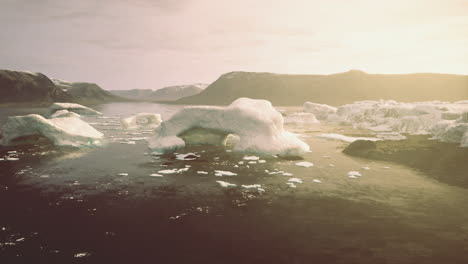 large icebergs float on still waters under the warm glow of sunset