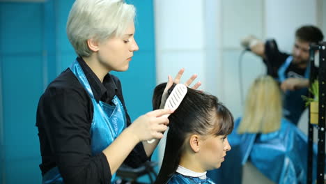young woman and hairdresser making styling hair at beaty salon