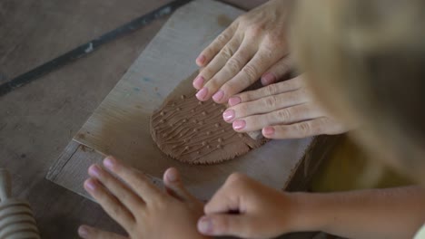 a young woman and her little son on a pottery master class