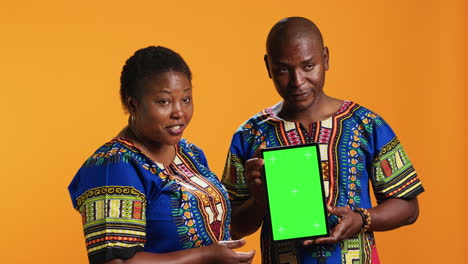 married people pointing at tablet with greenscreen layout