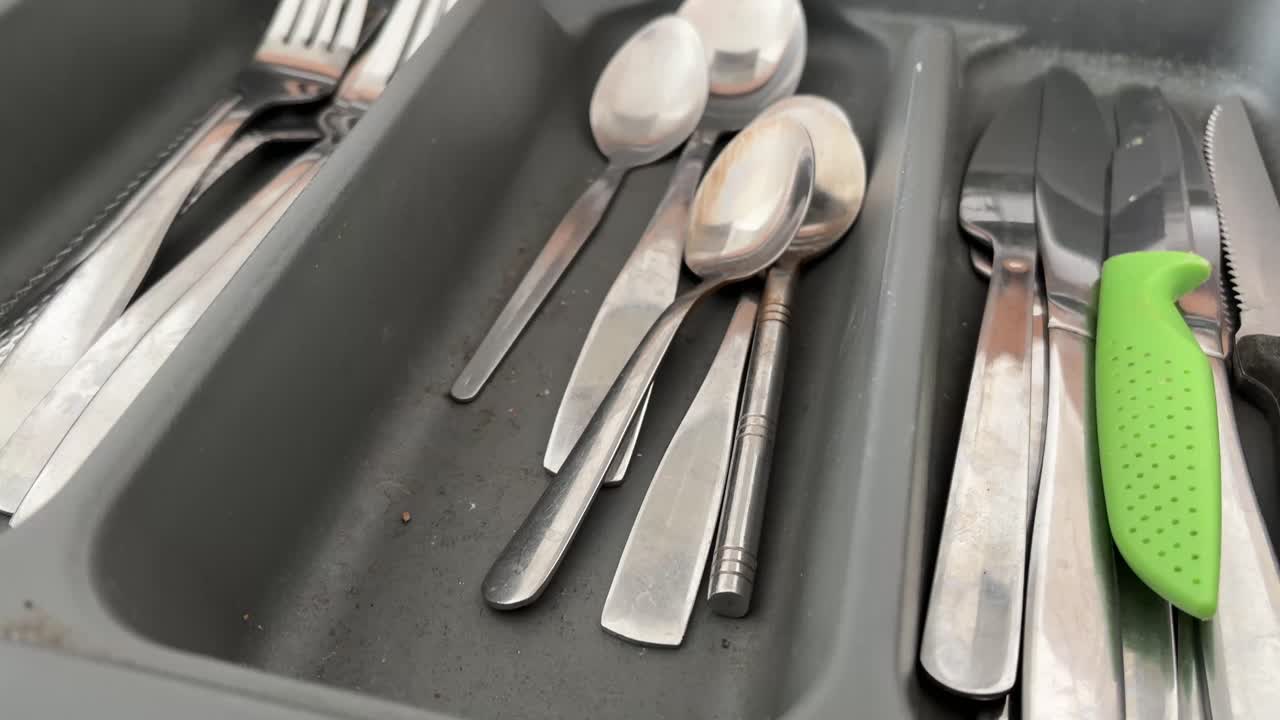 Lähikuva veitsistä, haarukasta, lusikasta ja aterimien laatikosta keittiössä, ruoanlaittovälineet