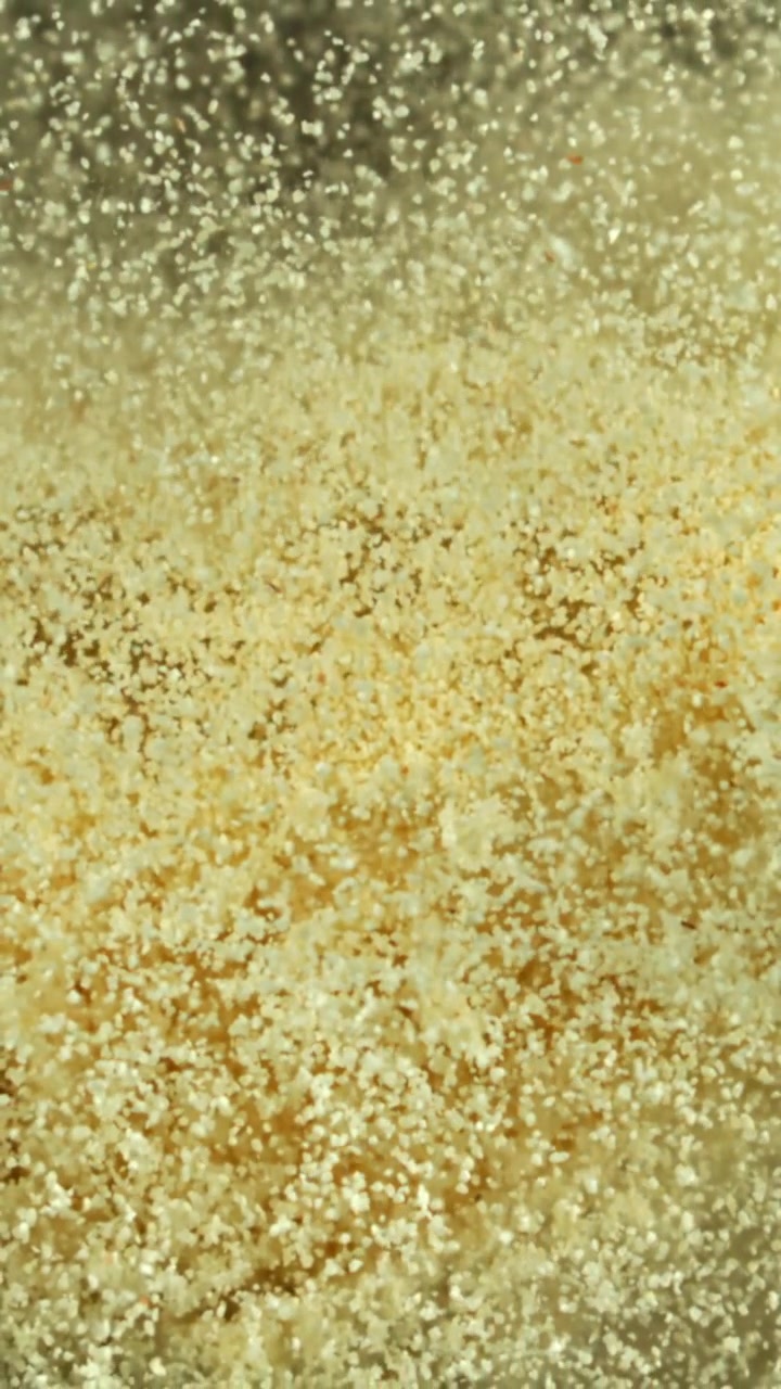 Macro-opname van fijne gouden deeltjes die vallen