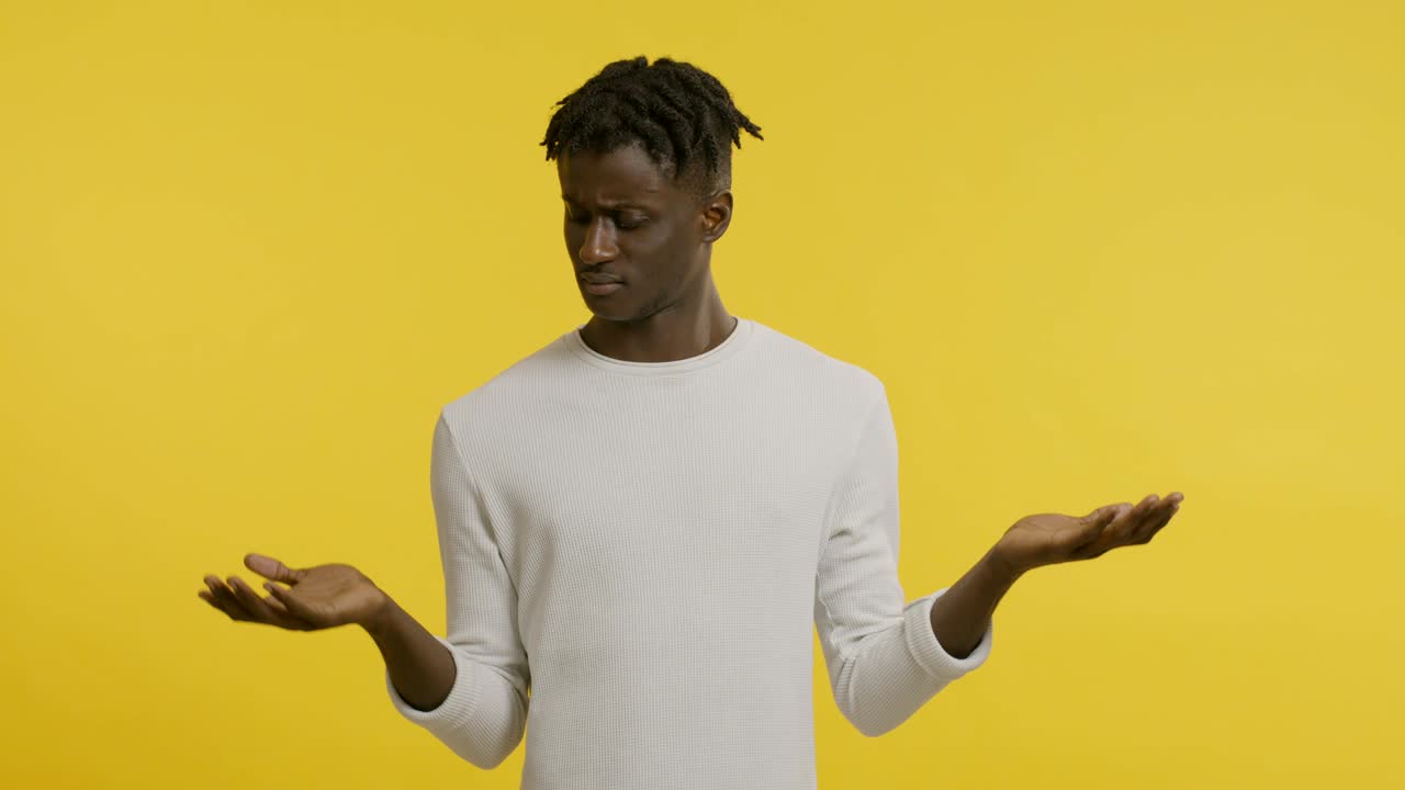 Doubtful african guy choosing between right and left hands