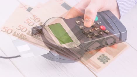 animación de billetes en euros que caen sobre la mano de un hombre caucásico que tiene una terminal de pago