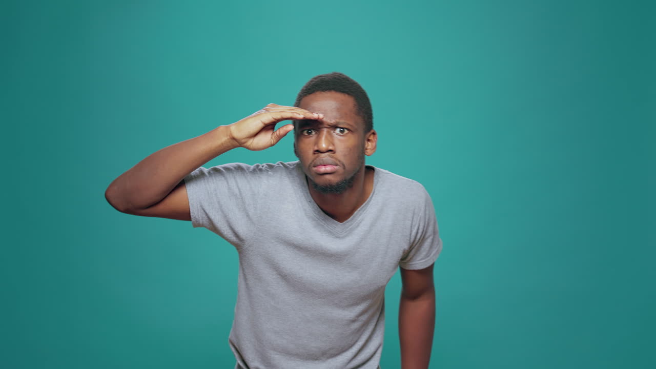 Confused person using hand over forehead to look around