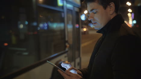 Hombre-Escribiendo-Cartas-En-Tablet-Pc-Mientras-Espera-El-Autobús