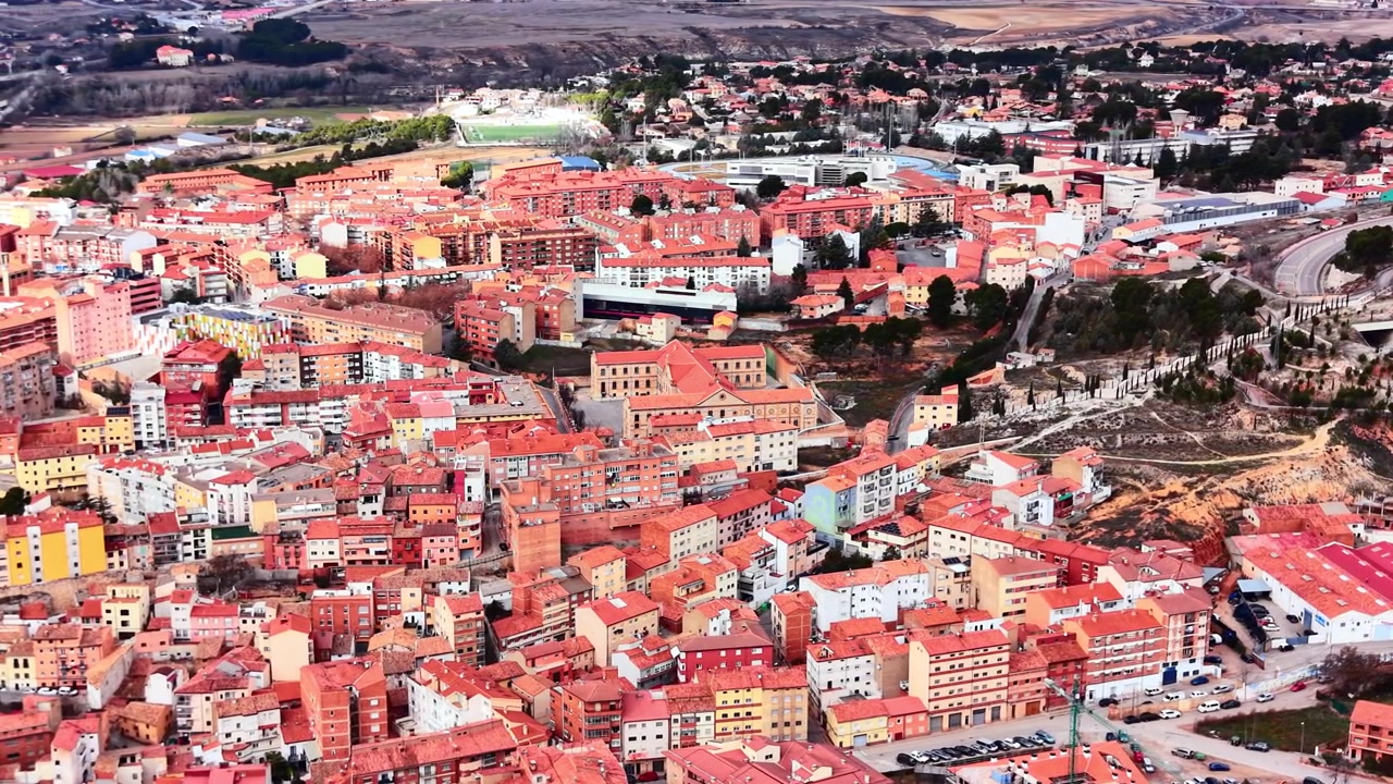 Luftfoto af et tæt befolket boligområde i Teruel, der viser boligblokke, tage og parkeringspladser.