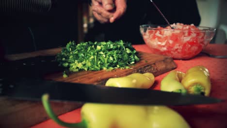 close up of a chef cutting coriander in the cutting board to add this to the salad